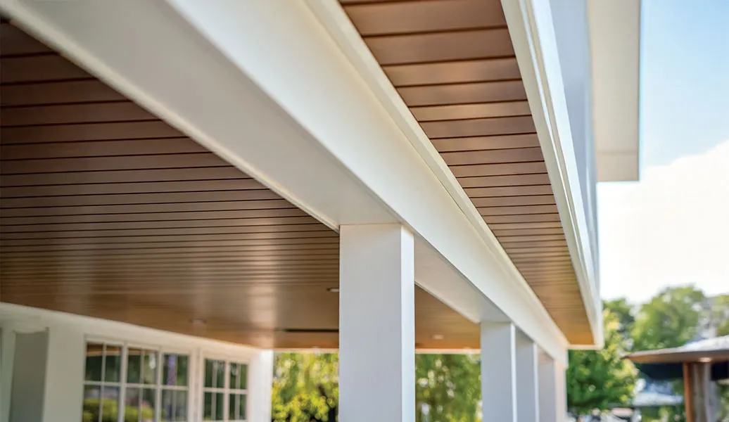 Finished under deck ceiling system, Inside Out by Quality Edge, viewed along a porch with columns
